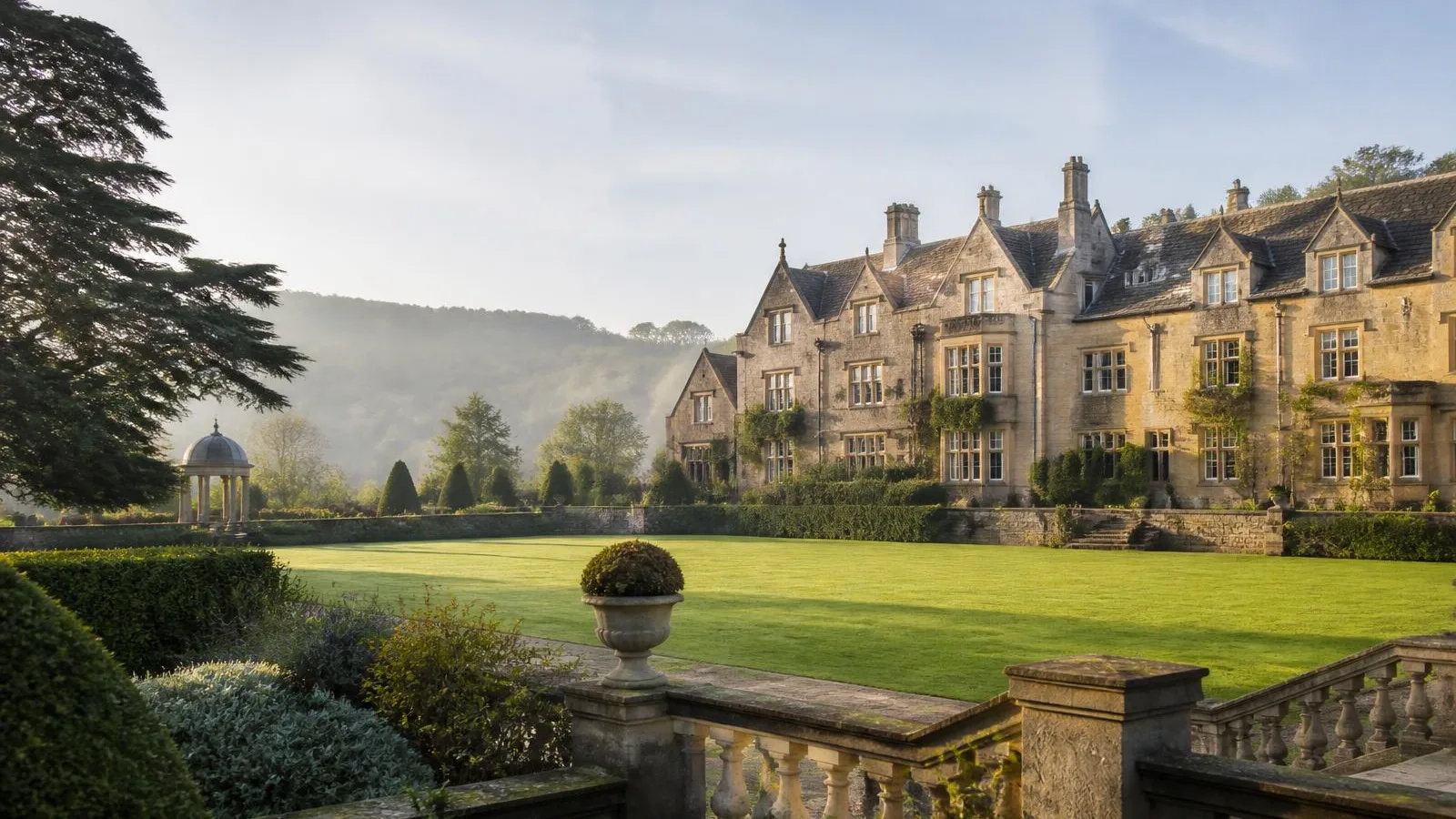 Cotswold country house estate with lawns and parkland on a misty morning