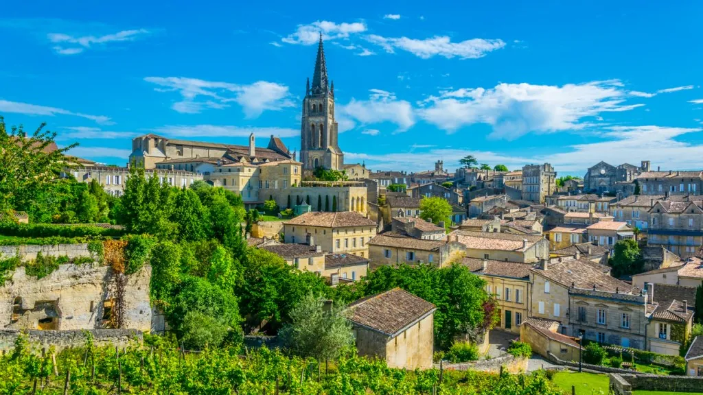 Aerial view of the stone village of Saint-Émilion and its church spire, surrounded by Bordeaux vineyards